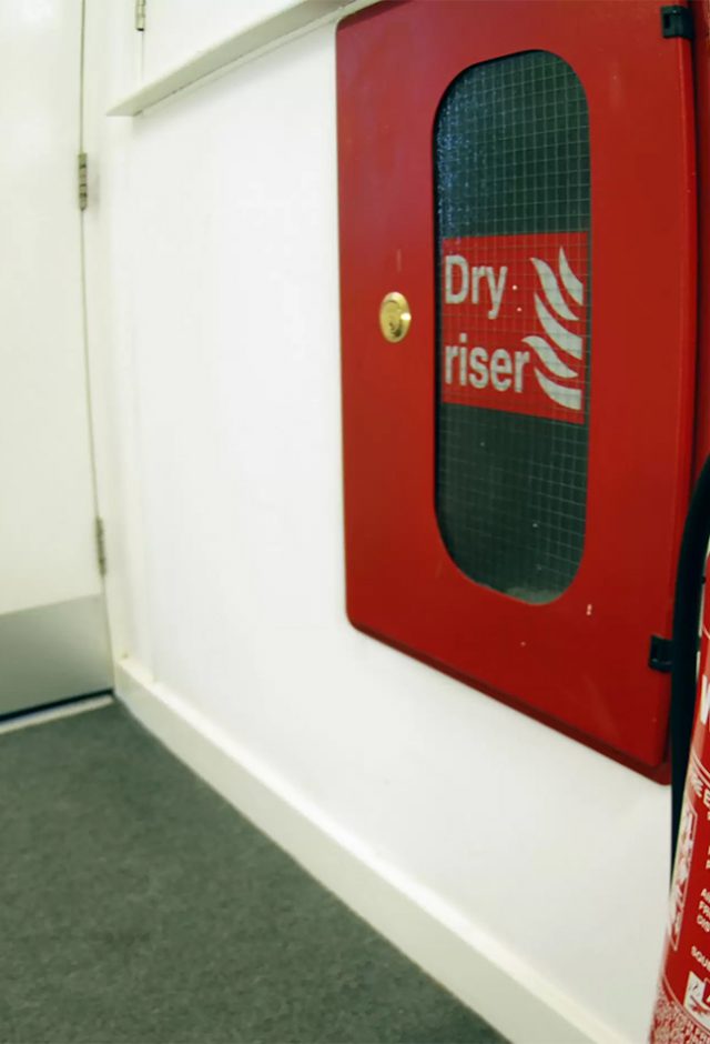 a water fire extinguisher next to a dry riser panel