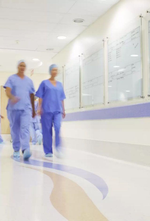 doctors and nurses walking along a hospital corridor