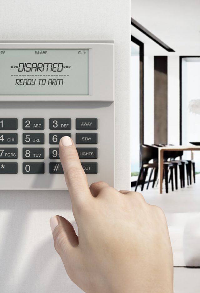 hand touching keypad on home security alarm system